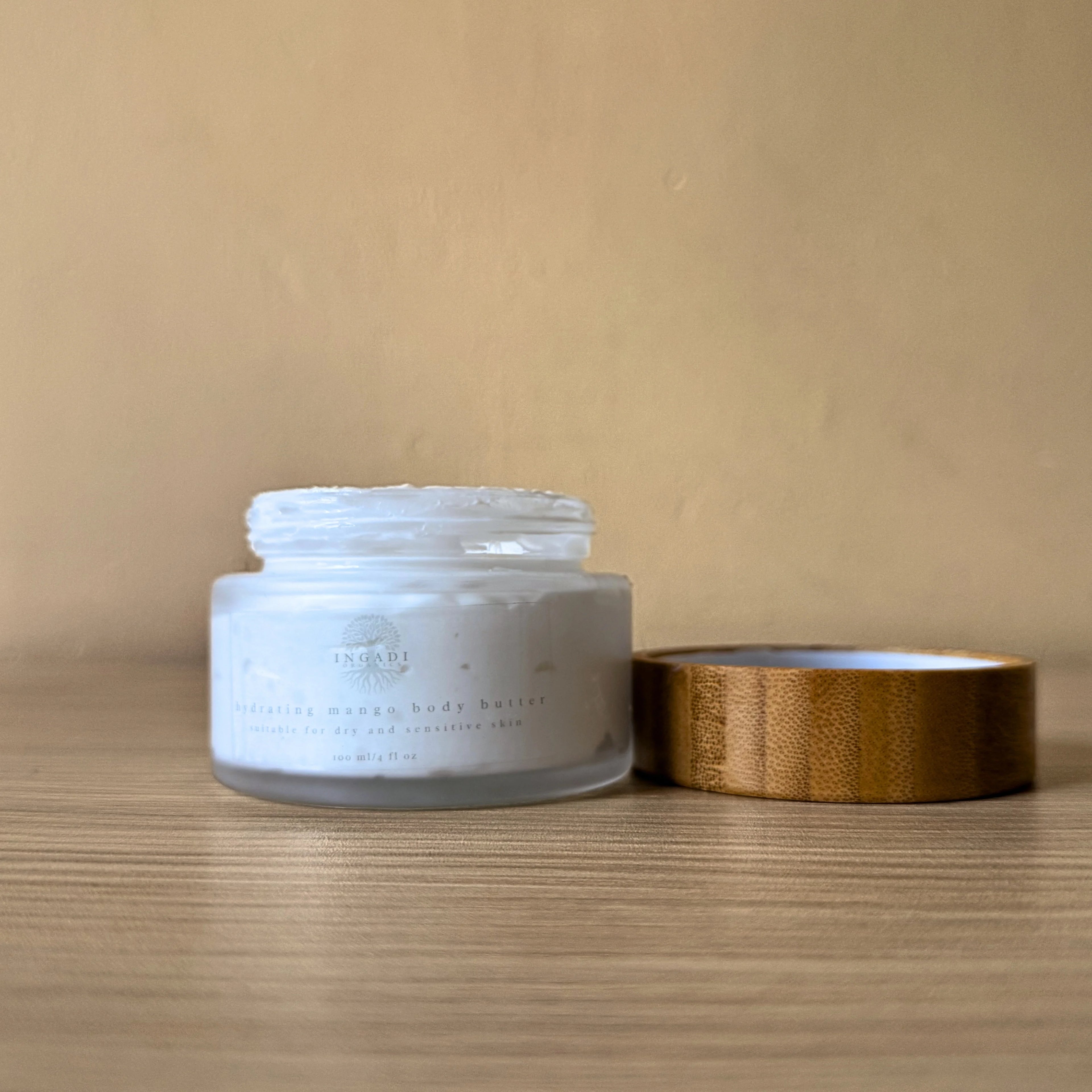 White jar with wooden lid on a wooden surface against a beige background