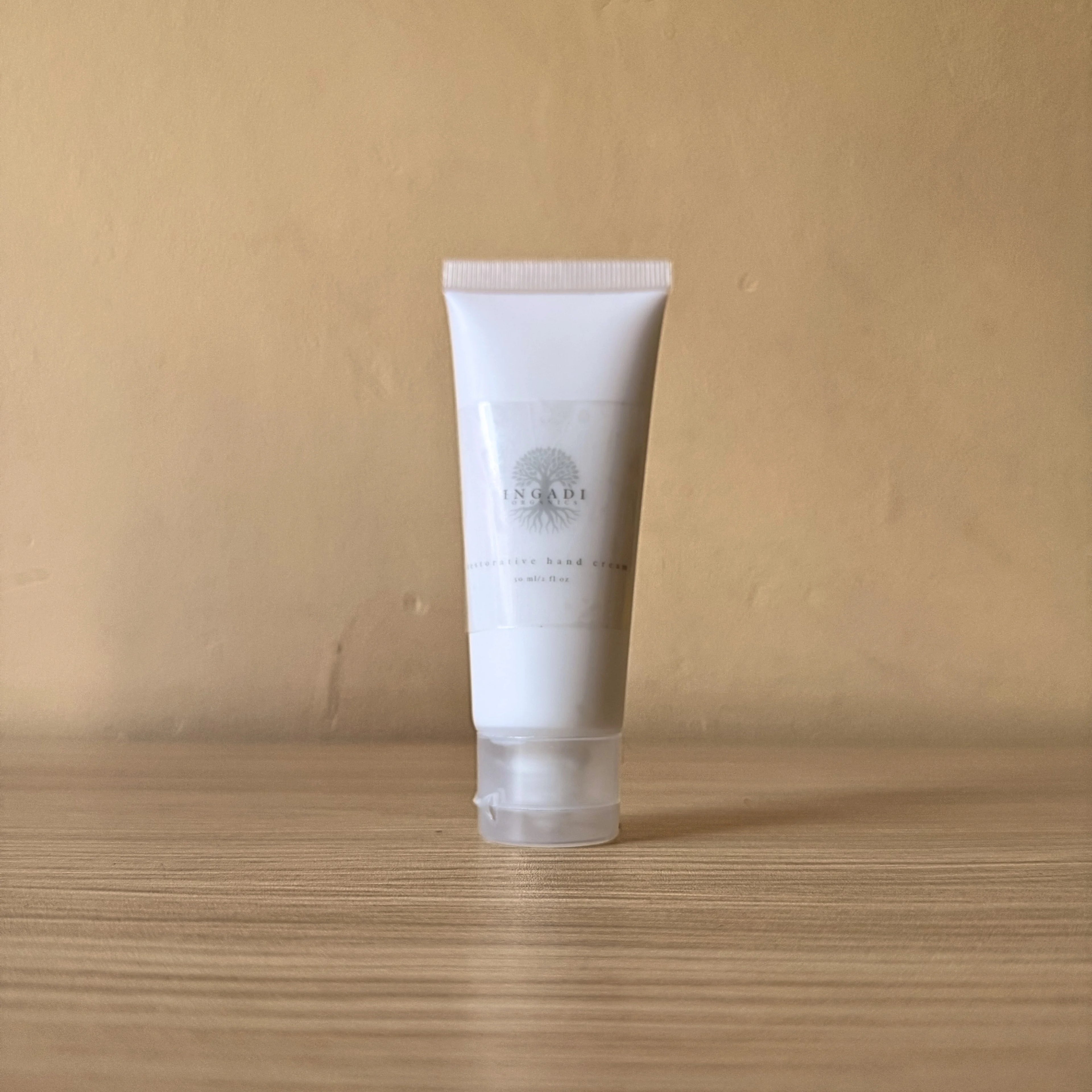 White tube of skincare product on a wooden surface with a beige background
