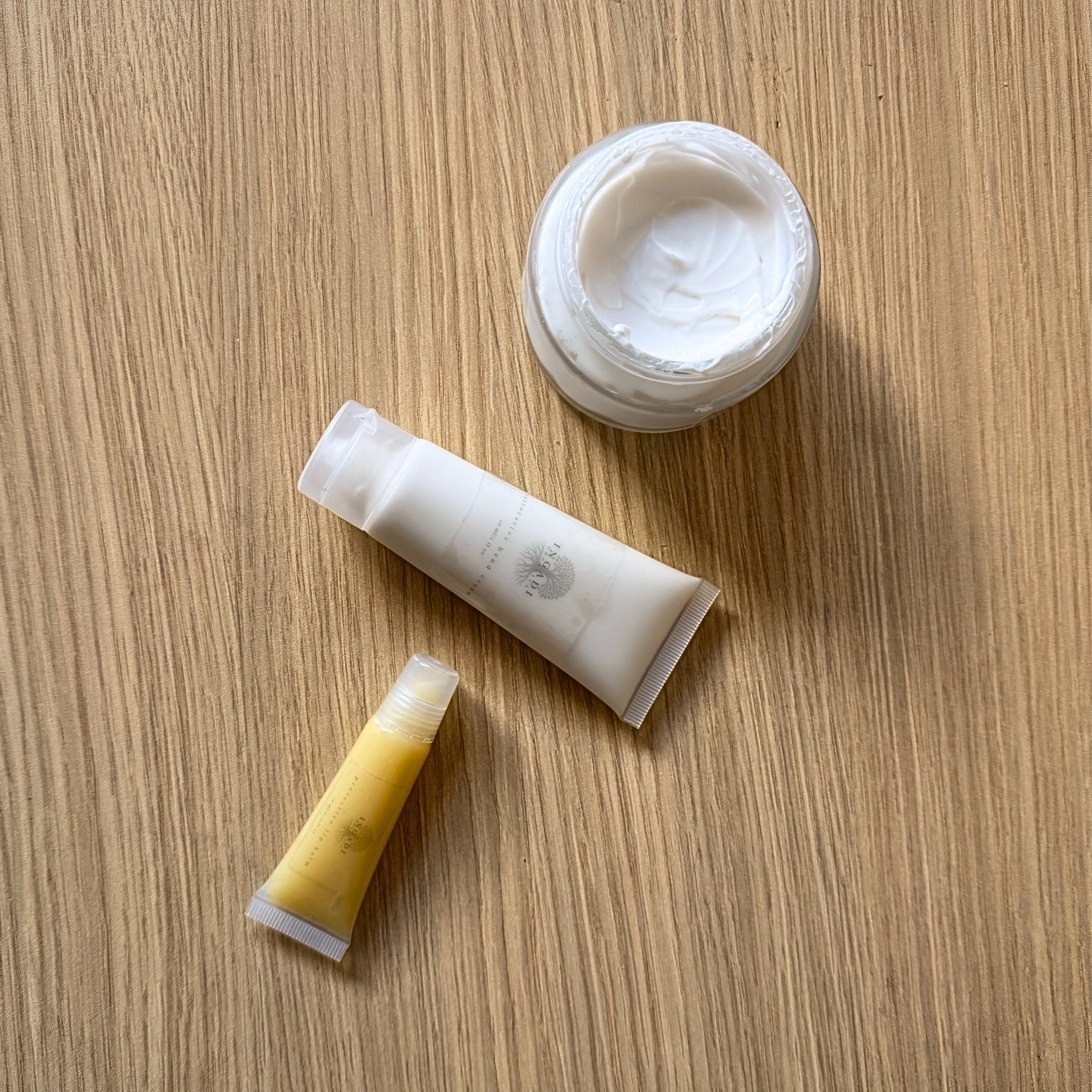 Three skincare products on a wooden surface
